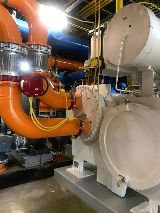 Industrial chiller with orange and blue piping in a mechanical room